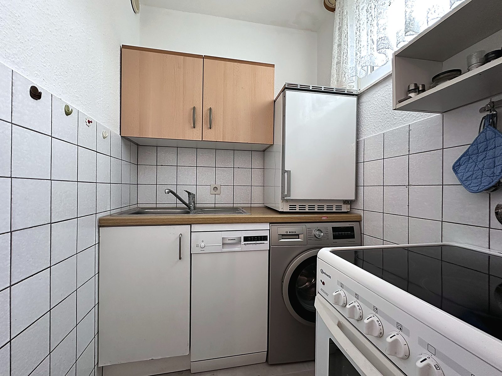 Küchenzeile mit Kühlschrank und Geschirr – Monteurwohnung Bad Soden-Salmünster